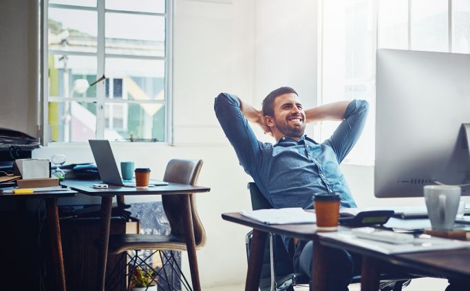 Employee leaning back comfortably at his desk.